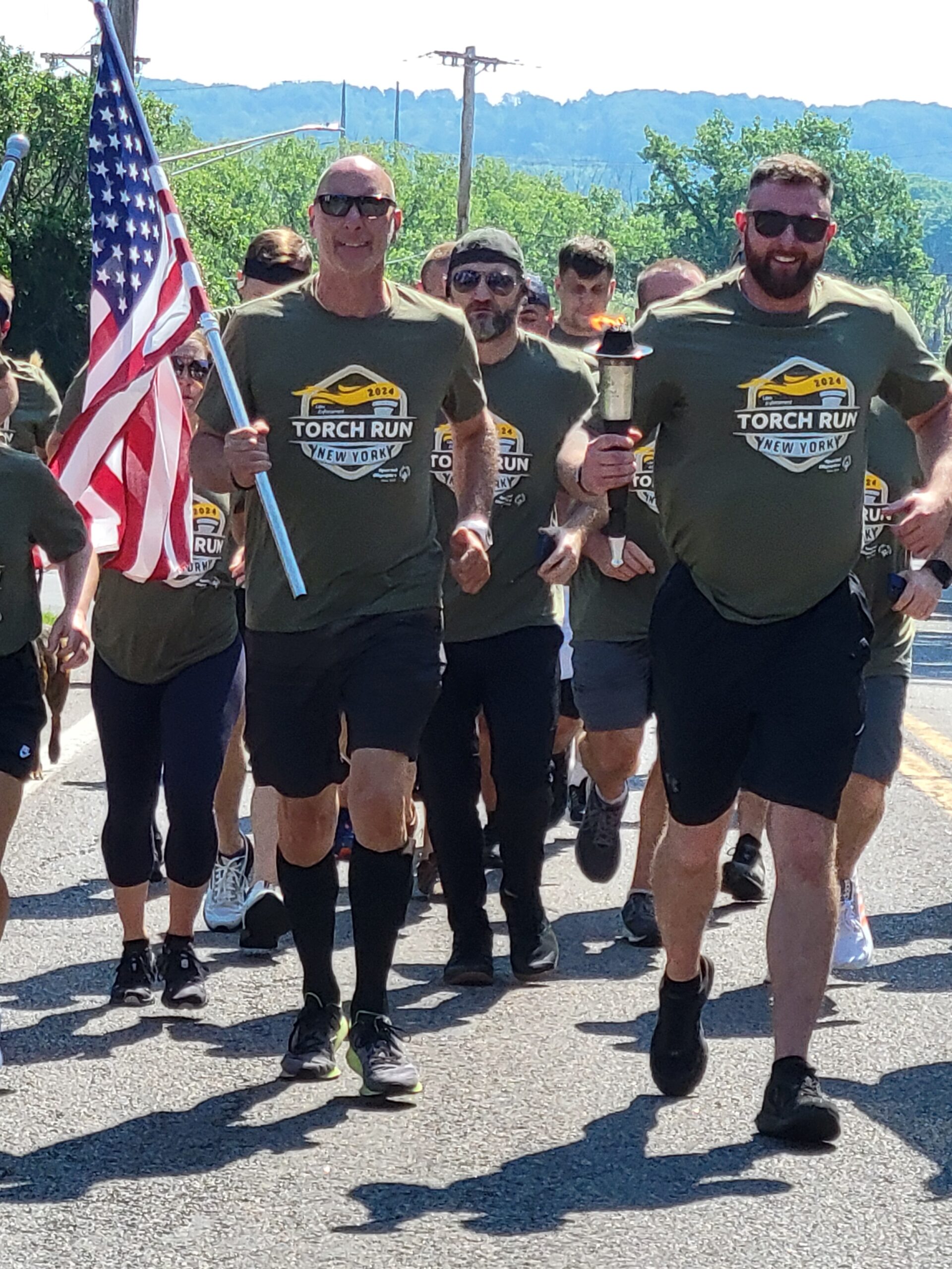 two runners with american flag and Torch