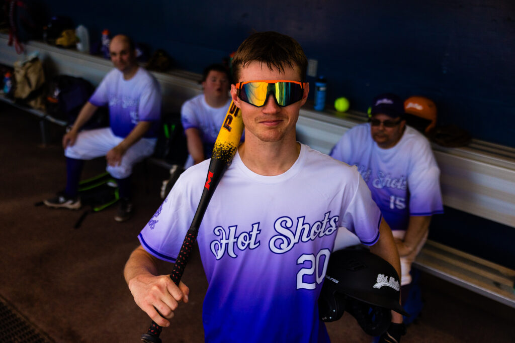 An athlete smiles for a photo from the dugout.